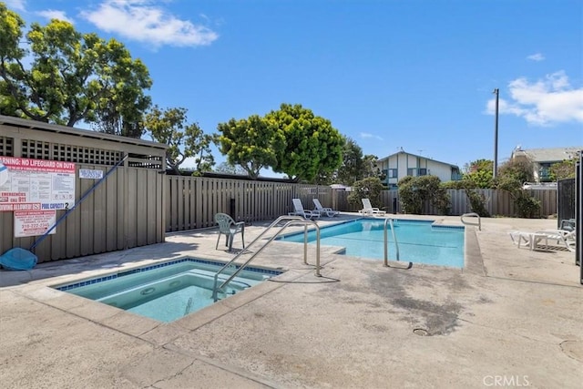 community pool with a community hot tub, fence, and a patio