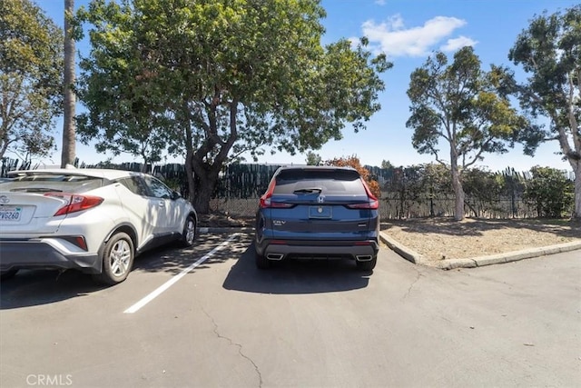 uncovered parking lot featuring fence