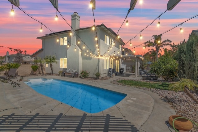 pool at dusk featuring a fenced in pool, a patio area, a gazebo, and fence