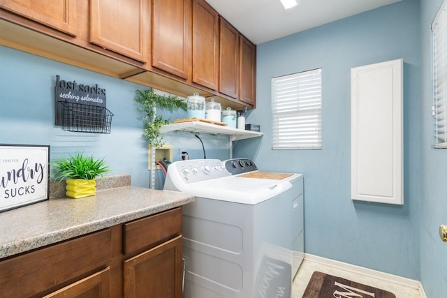 laundry room with cabinet space, washing machine and clothes dryer, and baseboards