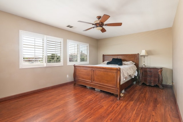 bedroom with ceiling fan, visible vents, baseboards, and dark wood finished floors