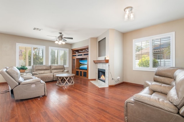 living area with a wealth of natural light, visible vents, and wood finished floors