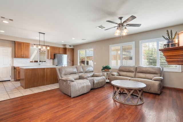 living area with visible vents, light wood finished floors, recessed lighting, and a ceiling fan