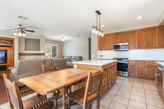 32133 Kale Ln, Winchester, CA 92596 - kitchen featuring appliances with stainless steel finishes, light countertops, brown cabinetry, tasteful backsplash, and a ceiling fan