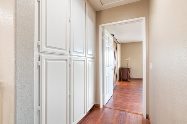 corridor featuring baseboards and wood finished floors