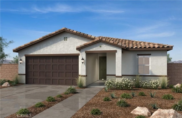 mediterranean / spanish house with concrete driveway, stucco siding, a tile roof, a garage, and fence