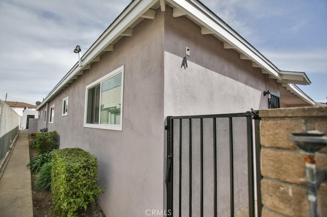 1608 N Placentia Ave, Fullerton, CA 92831 - view of side of home featuring stucco siding, fence, and a gate