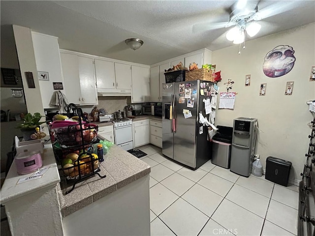 1608 N Placentia Ave, Fullerton, CA 92831 - kitchen with under cabinet range hood, stainless steel fridge with ice dispenser, white gas range, a ceiling fan, and light tile patterned floors