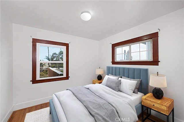 bedroom featuring baseboards and wood finished floors