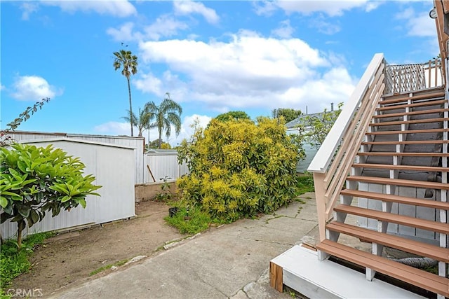 view of yard featuring an outdoor structure, a storage unit, and stairway