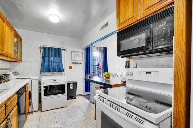 2807 W 129th, Gardena, CA 90248 - kitchen featuring black appliances, visible vents, brown cabinetry, decorative backsplash, and washing machine and clothes dryer