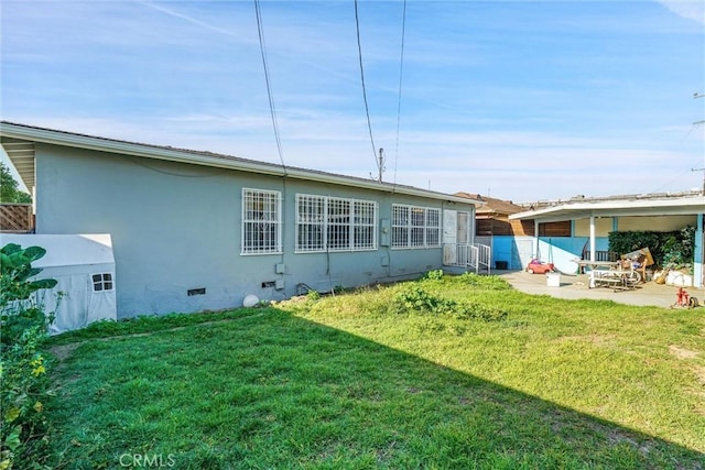 2807 W 129th, Gardena, CA 90248 - rear view of house with crawl space, a patio area, stucco siding, and a lawn