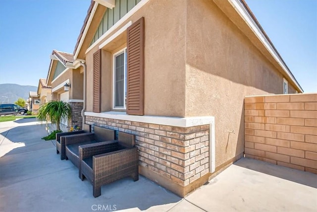 17985 Crabapple Ct, San Bernardino, CA 92407 - view of side of home with a mountain view, stucco siding, fence, and a patio area
