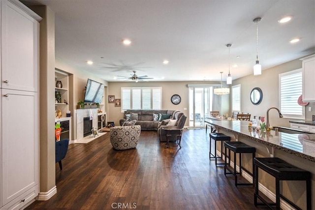 17985 Crabapple Ct, San Bernardino, CA 92407 - living room with ceiling fan, a fireplace with flush hearth, recessed lighting, dark wood-style flooring, and baseboards