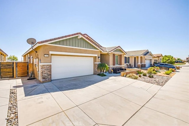 17985 Crabapple Ct, San Bernardino, CA 92407 - view of front of house with an attached garage, stone siding, fence, a gate, and driveway