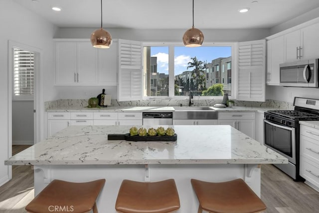 8000 7th St, Downey, CA 90241 - kitchen featuring a sink, light wood finished floors, a kitchen bar, and appliances with stainless steel finishes