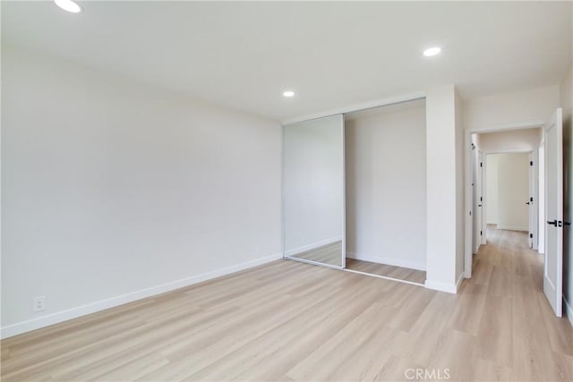 unfurnished bedroom with baseboards, light wood finished floors, and recessed lighting