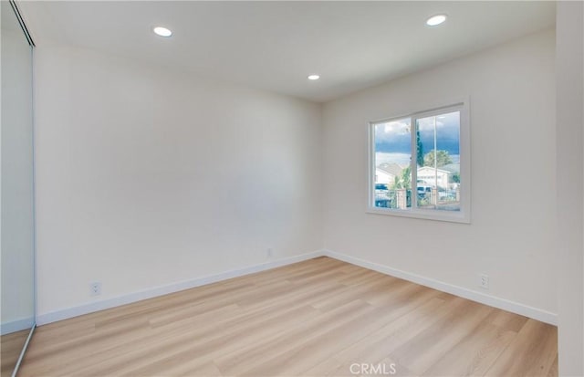 unfurnished room with recessed lighting, light wood-style floors, and baseboards