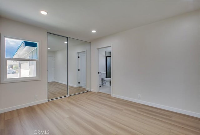 unfurnished bedroom with recessed lighting, light wood-type flooring, and baseboards