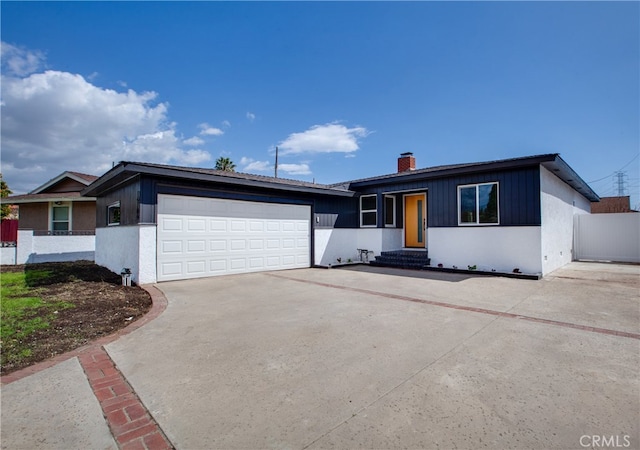ranch-style home with a garage, driveway, fence, and a chimney