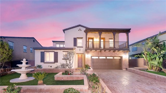 15448 Six M Ranch Ln, Fontana, CA 92336 - view of front facade with a balcony, driveway, stucco siding, a garage, and brick siding