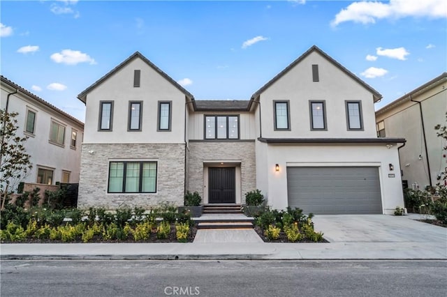 view of front facade featuring an attached garage, concrete driveway, and stucco siding