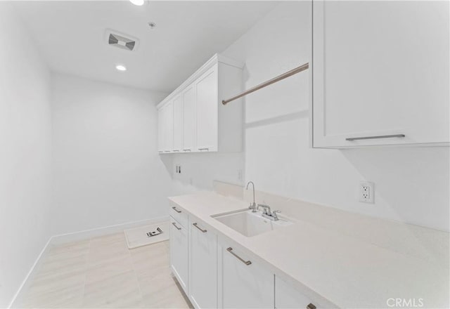washroom with visible vents, a sink, baseboards, and recessed lighting