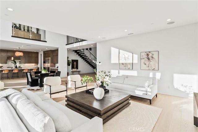 living room with light wood-style flooring, stairway, and recessed lighting