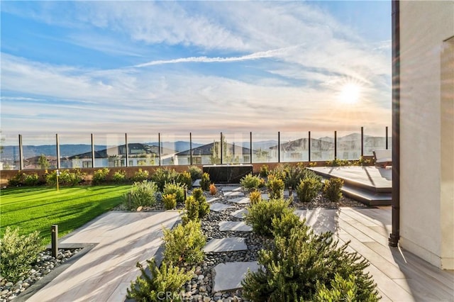 view of property's community featuring a patio, a mountain view, and a lawn
