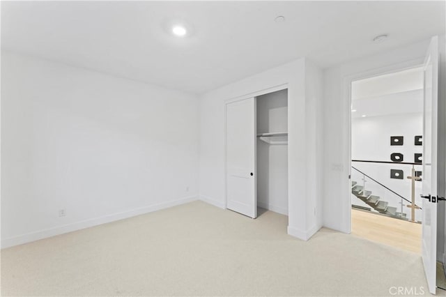 unfurnished bedroom with a closet, carpet flooring, and baseboards