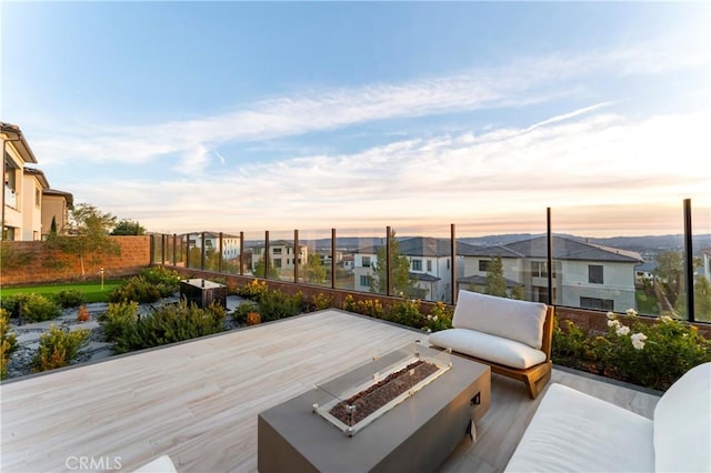 wooden deck featuring a residential view and a fire pit