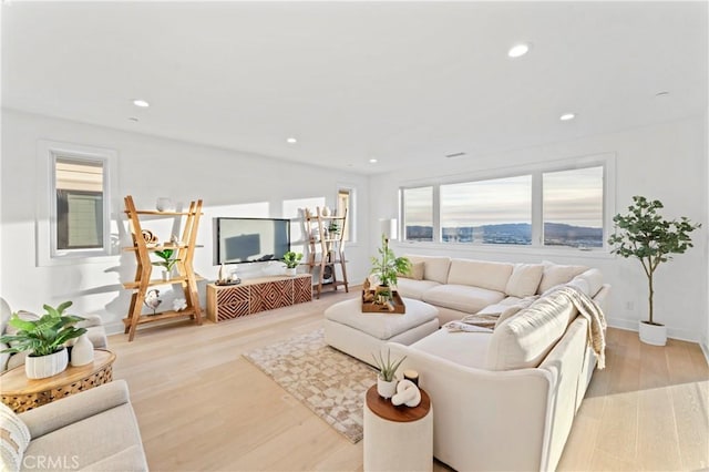 living room with recessed lighting, light wood finished floors, and baseboards