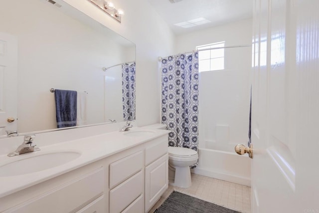full bathroom featuring toilet, tile patterned floors, double vanity, and a sink