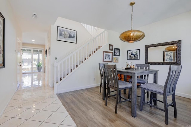 dining area with stairway, baseboards, and wood finished floors