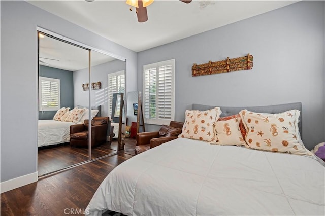 bedroom with a closet, ceiling fan, wood finished floors, and baseboards