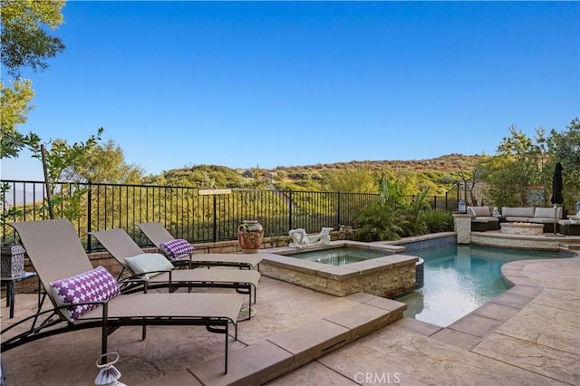 view of pool featuring a pool with connected hot tub, outdoor lounge area, fence, and a patio