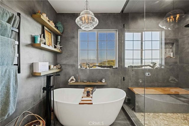 bathroom with a freestanding bath, an inviting chandelier, and a stall shower