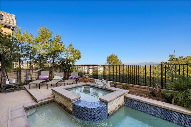 view of pool featuring a patio area, a fenced backyard, and an in ground hot tub