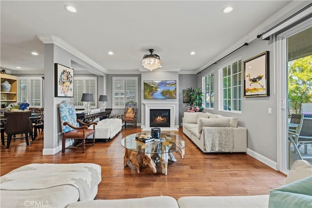 living area featuring crown molding, recessed lighting, and plenty of natural light