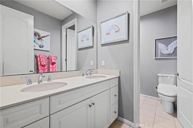bathroom featuring tile patterned floors, double vanity, a sink, and toilet