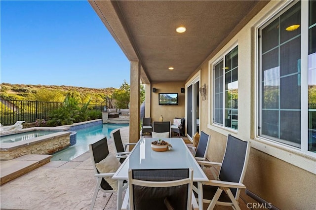 view of patio / terrace featuring a fenced in pool, outdoor lounge area, an in ground hot tub, outdoor dining area, and fence