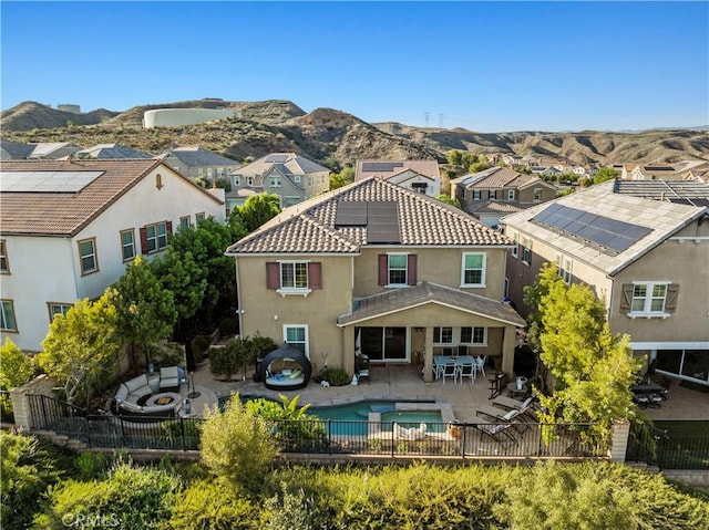 rear view of house featuring a mountain view, a patio area, a fenced backyard, outdoor dining space, and a residential view