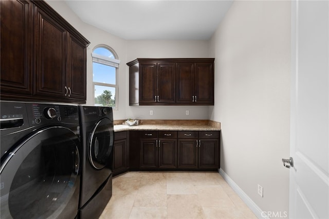 washroom with separate washer and dryer, cabinet space, and baseboards