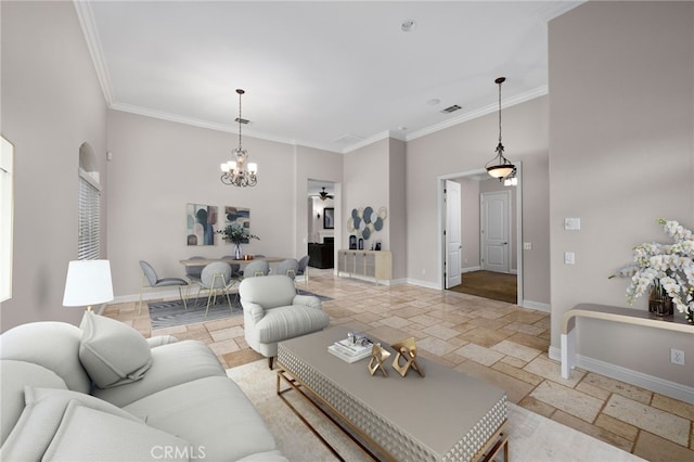 living area with stone tile floors, baseboards, ornamental molding, and a chandelier