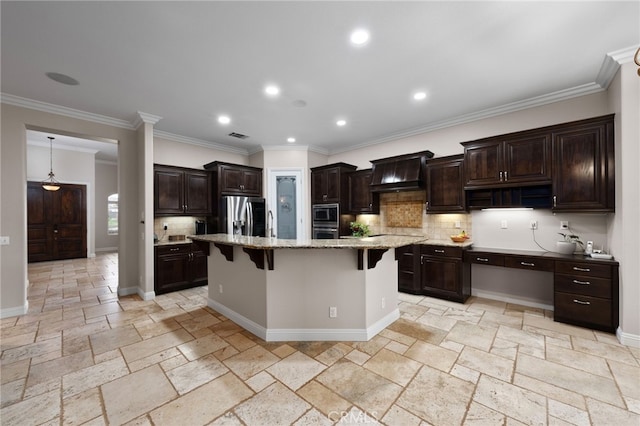 kitchen with custom exhaust hood, stainless steel appliances, stone tile flooring, backsplash, and a kitchen bar