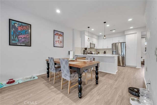 dining room featuring light wood finished floors, recessed lighting, and baseboards