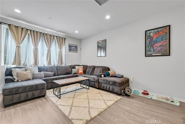 living room with wood finished floors, recessed lighting, and baseboards
