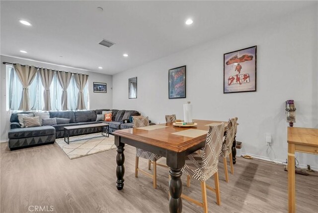 dining space featuring light wood finished floors, recessed lighting, and baseboards