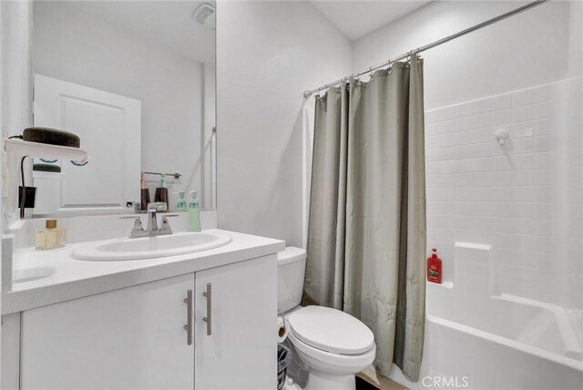 bathroom with toilet, vanity, and shower / bath combo with shower curtain
