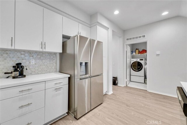 kitchen with stainless steel refrigerator with ice dispenser, light countertops, light wood finished floors, white cabinets, and decorative backsplash